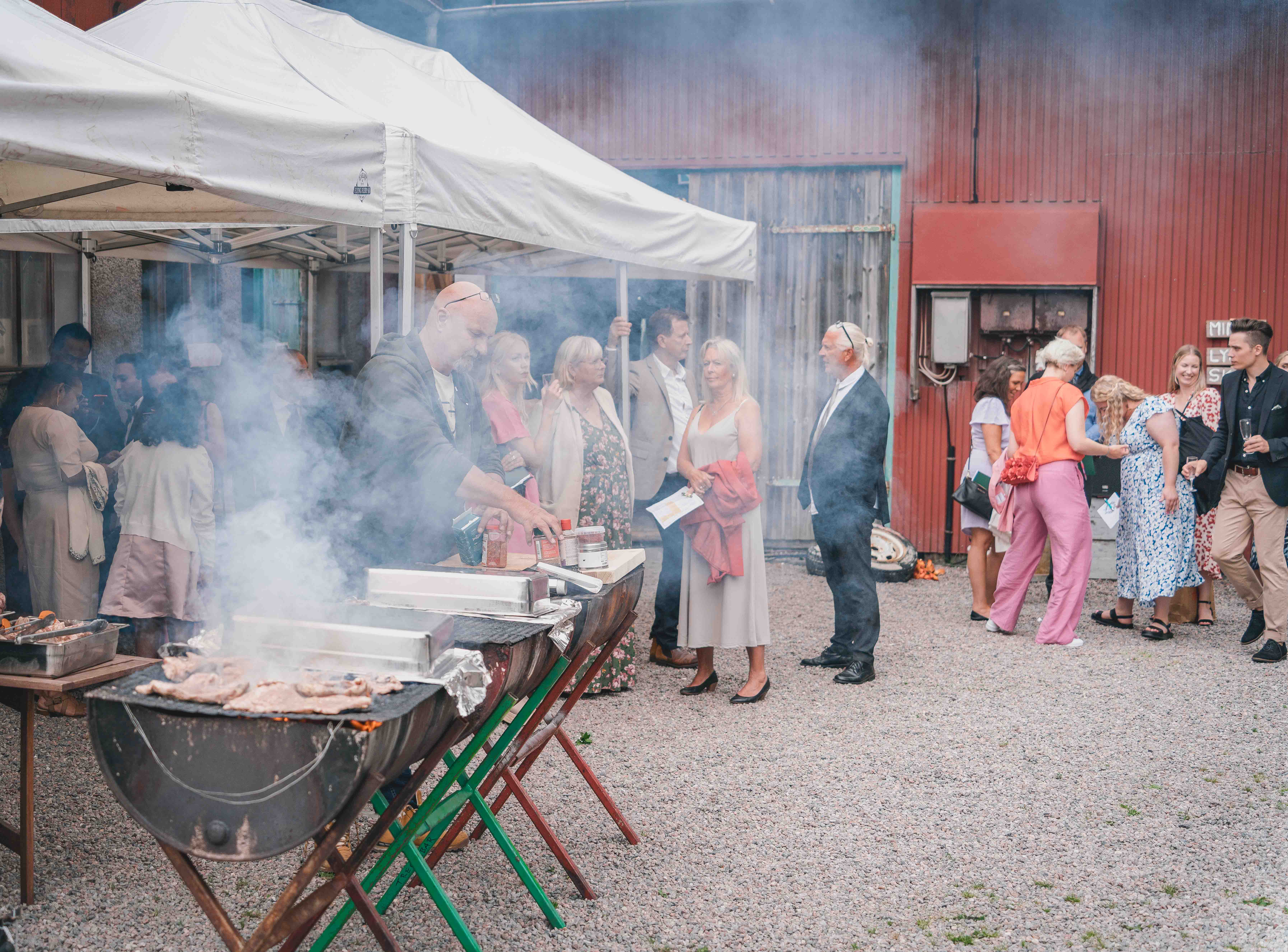 Vänner som grillar maten till bröllopsmiddagen