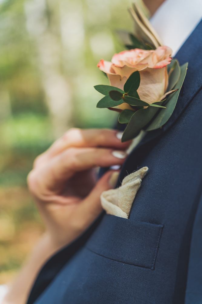 Närbild av en hand vid brudgummens knapphålsblomma