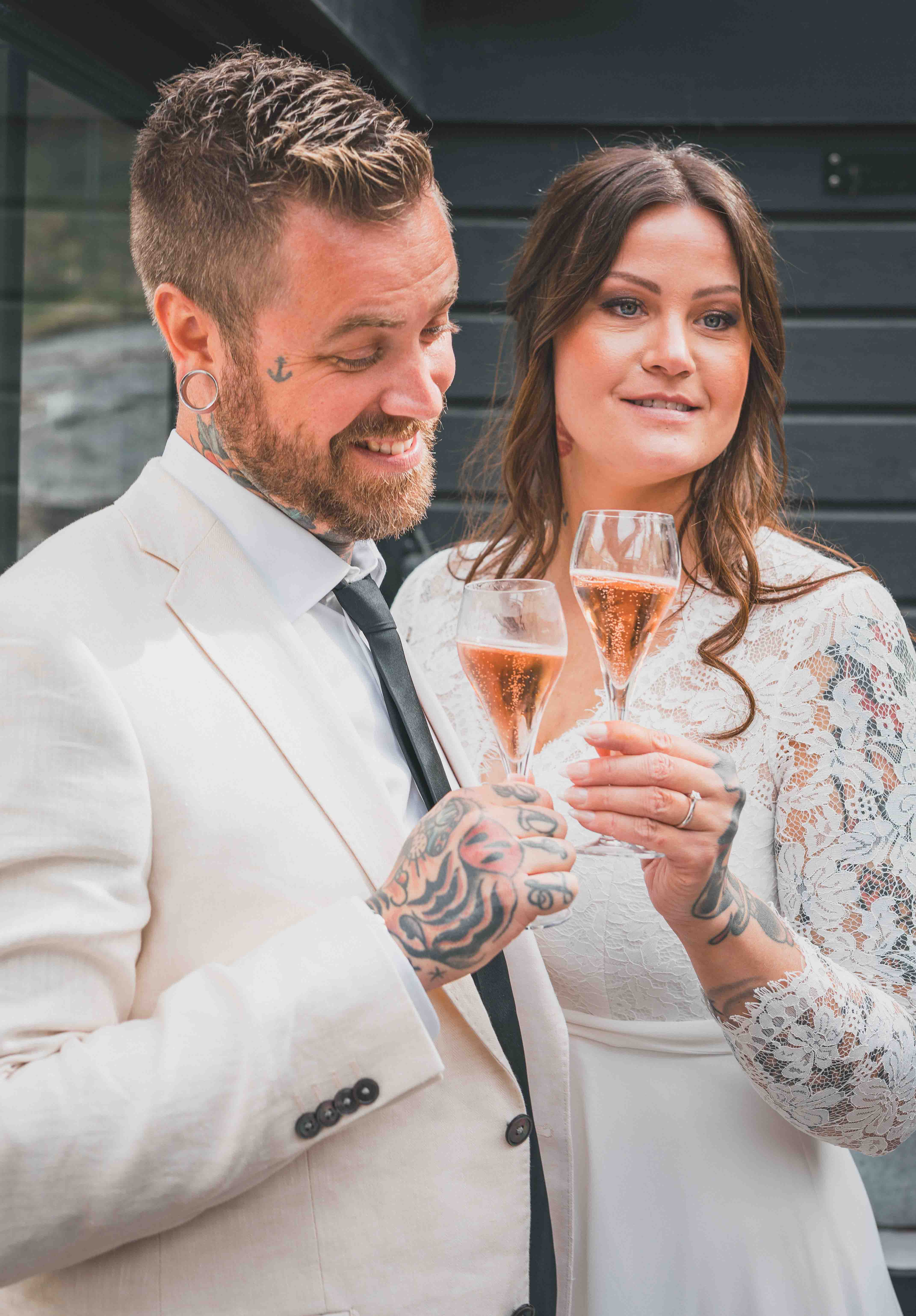 Rebecka och Aron skålar under bröllopsdagen
